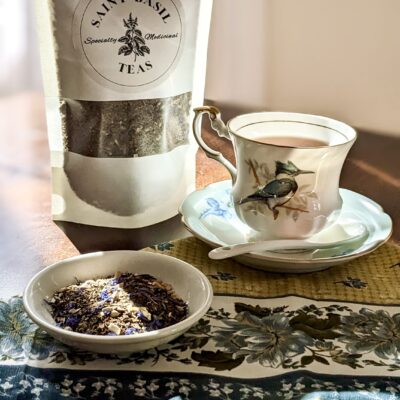 tea cup with bluebird on it and saint basil tea and loose leaf tea in a cup