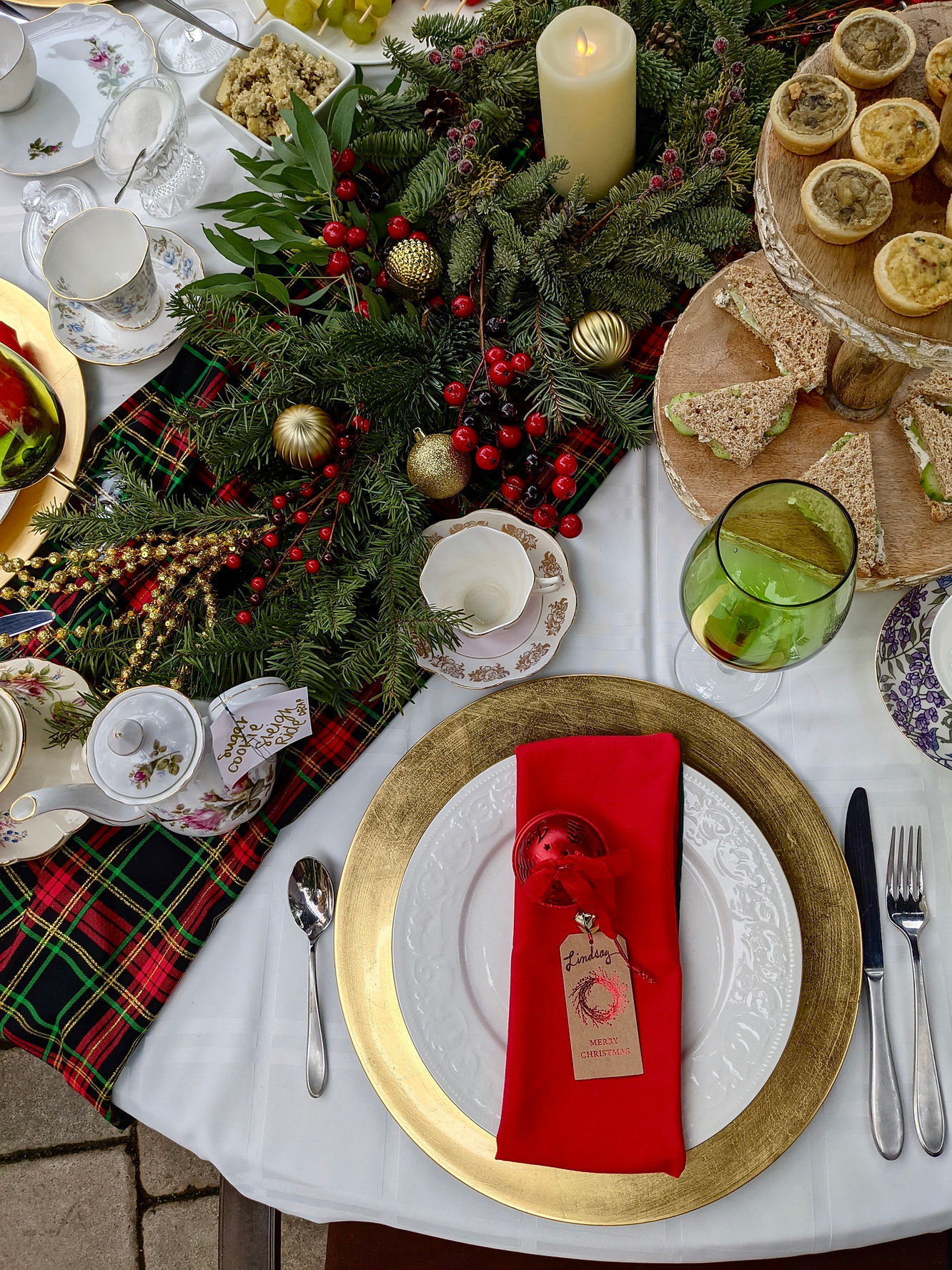 christmas tea table setting with pine garlands runner and gold plates