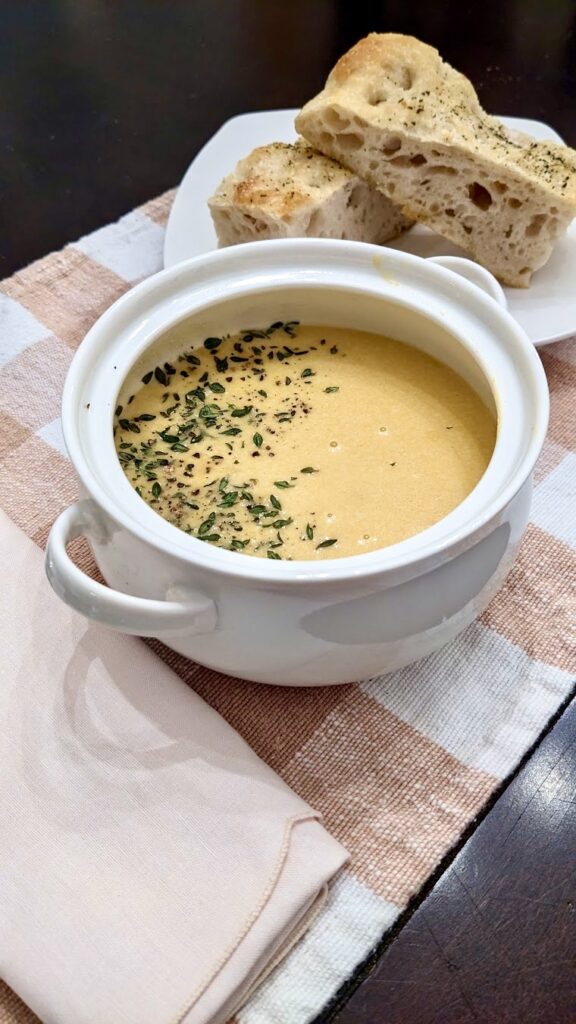 butternut squash soup on a placemat with napkin and bread