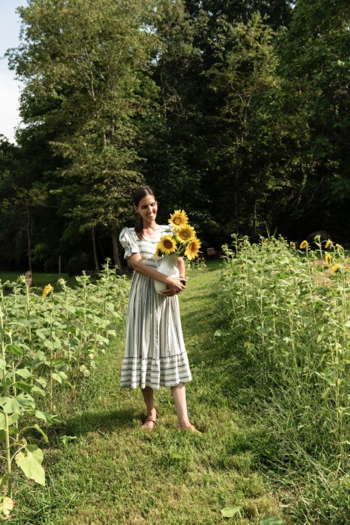 woman holding a vase of sunflowers