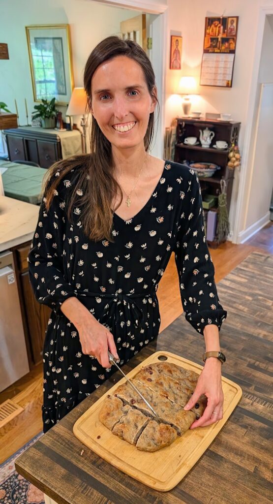 woman cutting focaccia bread in her kitchen